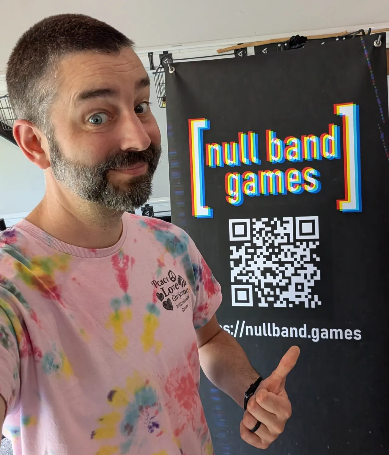 Jon Peck posing in front of a Null Band Games banner