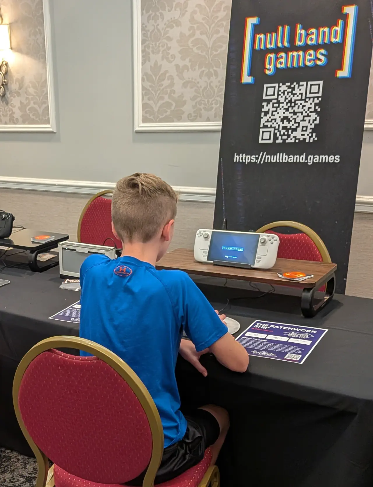 A younger expo attendee playtesting The Patchwork Ship while their friend watches